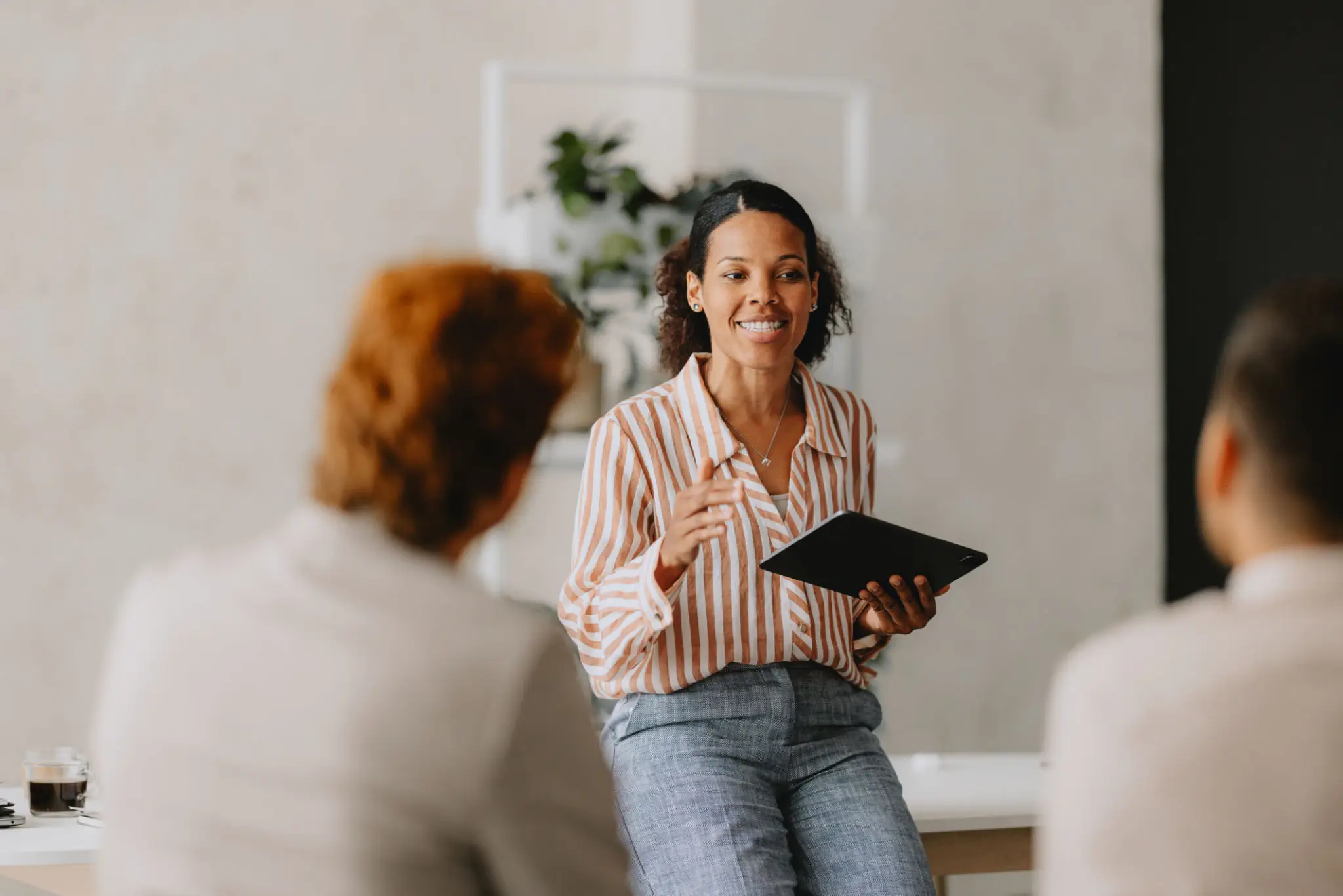 Woman presenting to team with tablet